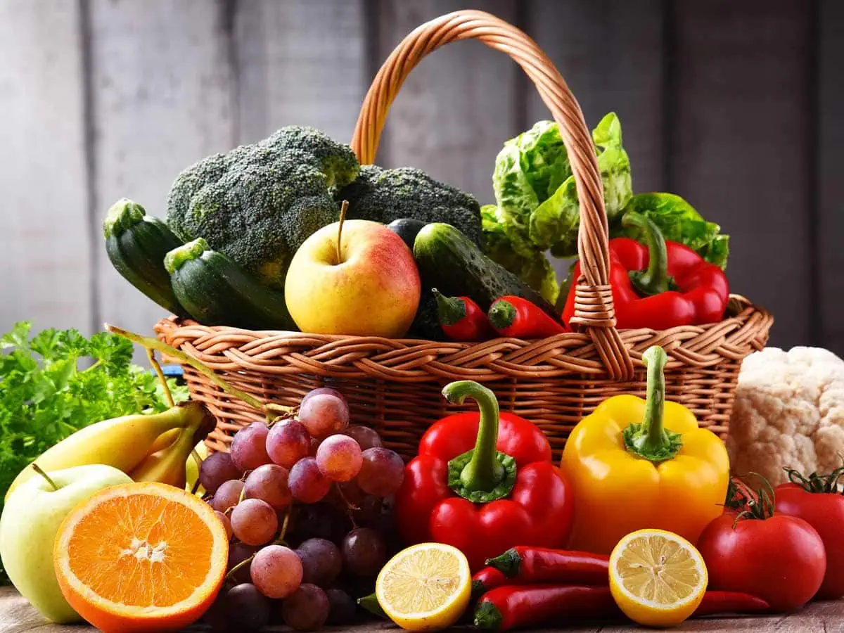 An arrangement of fresh fruit and vegetables in a basket.